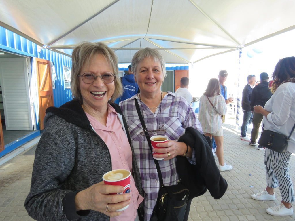 Two visitors of the YB Arena opening drinking a coffee.